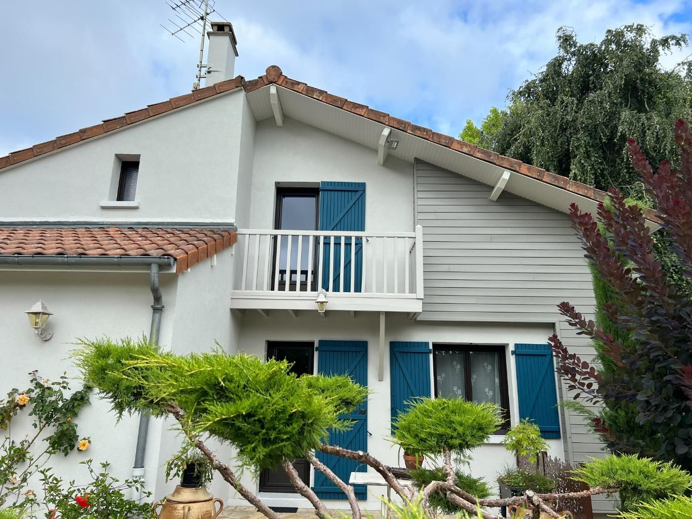 Une maison avec une porte bleue et des volets bleue.