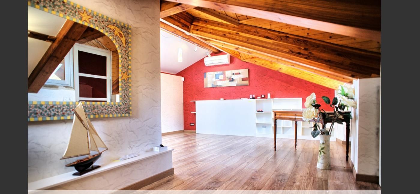 Une pièce avec un plafond en bois et un mur rouge.