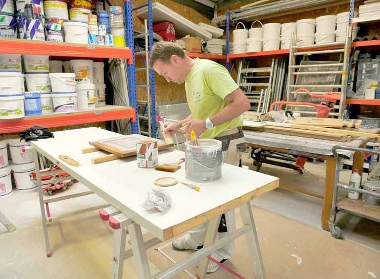 Un homme effectue des travaux de peinture dans un atelier