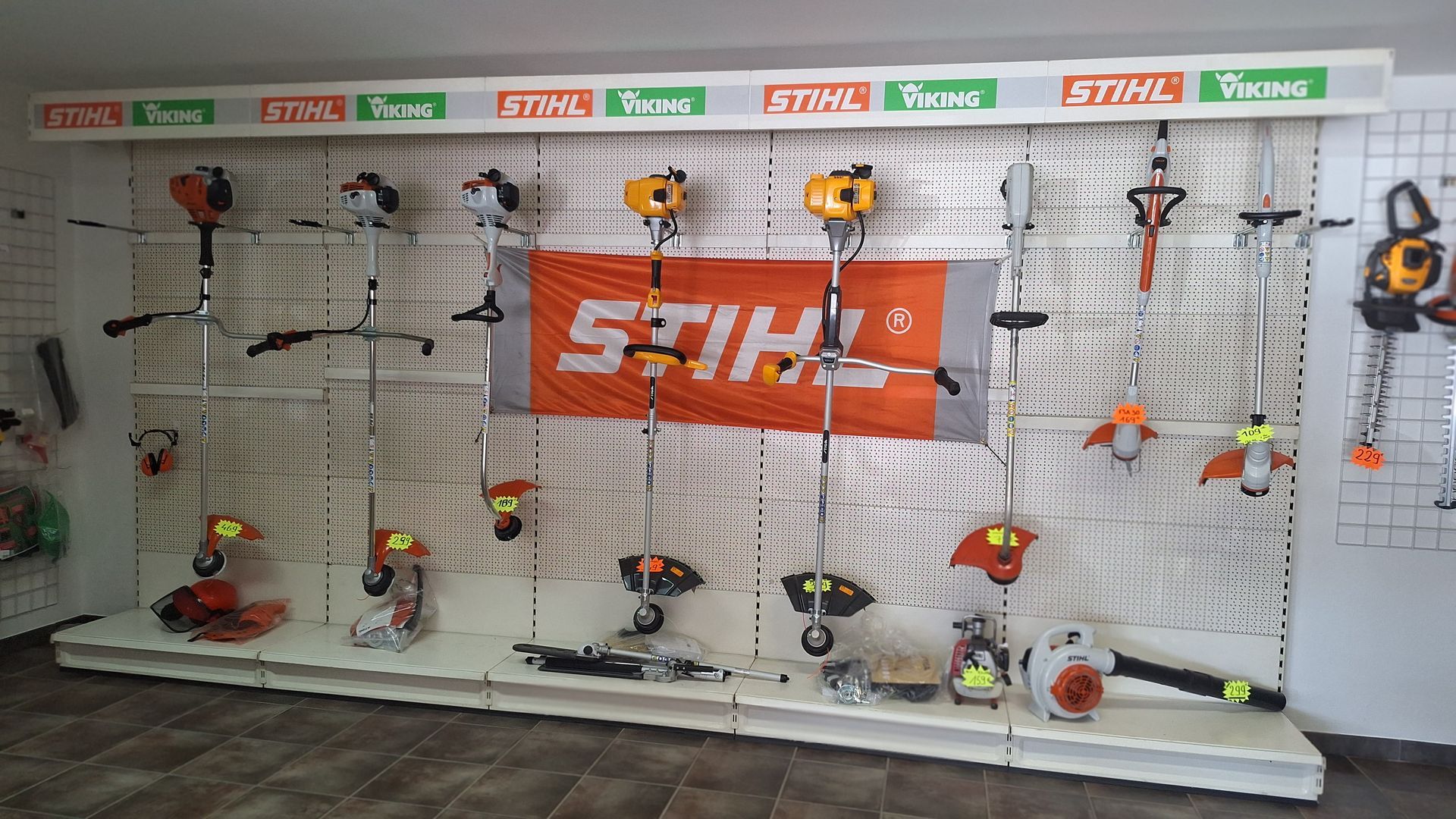 Un présentoir mural présentant divers équipements d'entretien de pelouse Stihl,