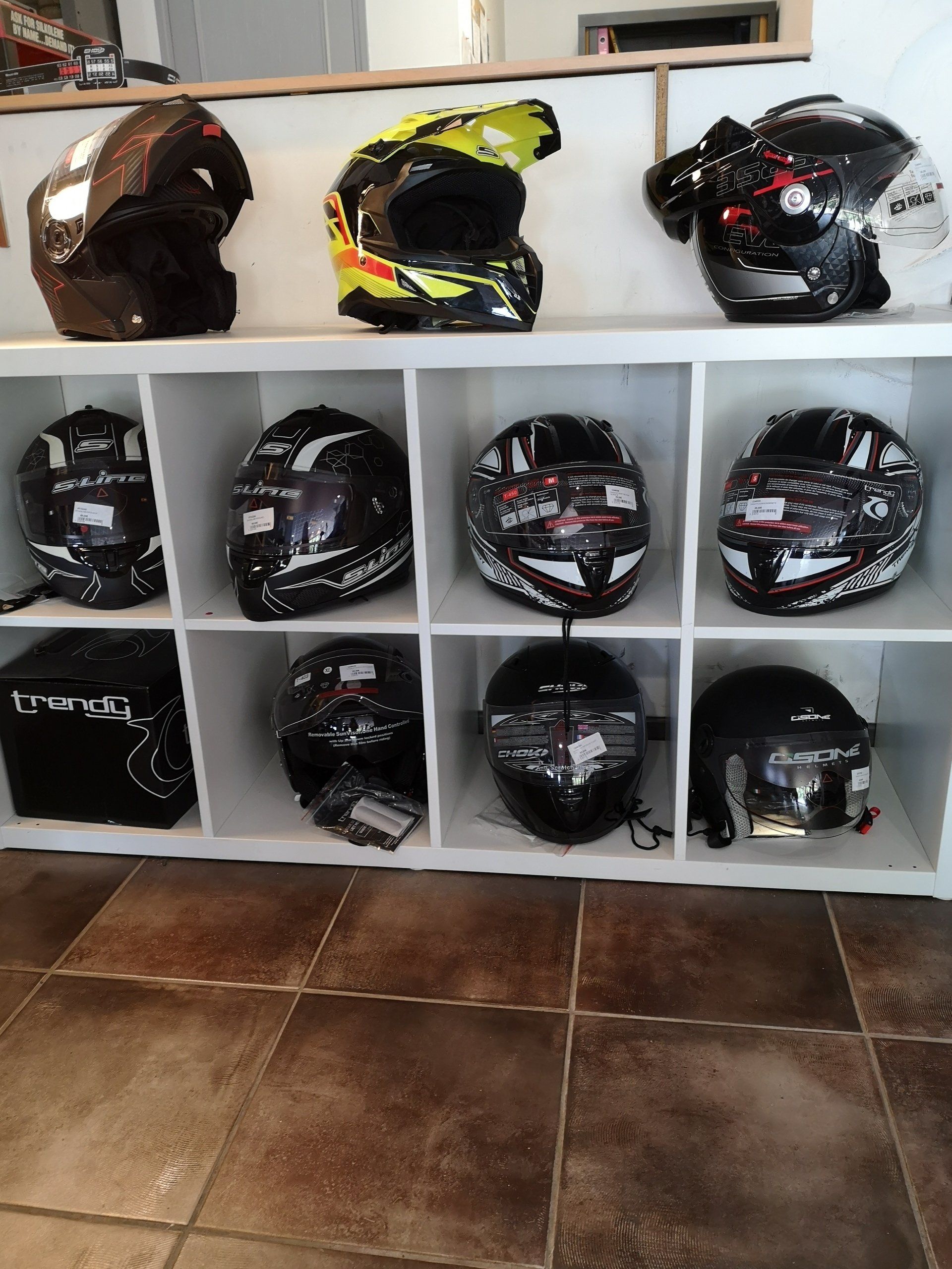 Série de casques de motos dans un casier blanc