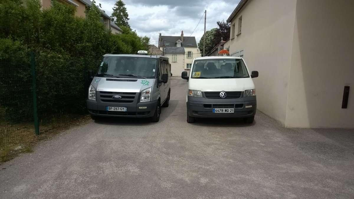 Deux minibus gris et blanc côte à côte.
