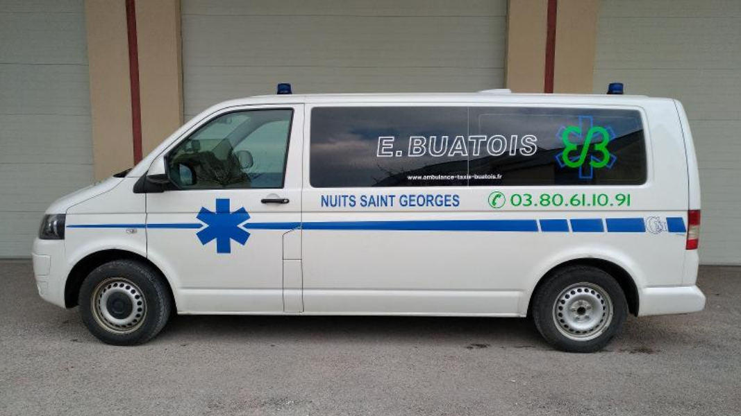 Ambulance blanche avec une étoile de vie bleue et le logo de l'entreprise sur le côté.