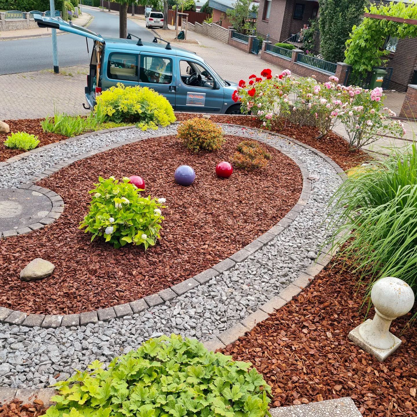 Ein blauer Lieferwagen steht mitten in einem Garten