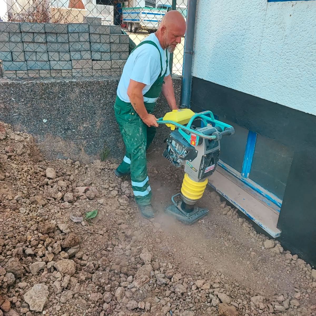 Ein Mann benutzt eine Maschine, um ein Loch in den Boden zu graben