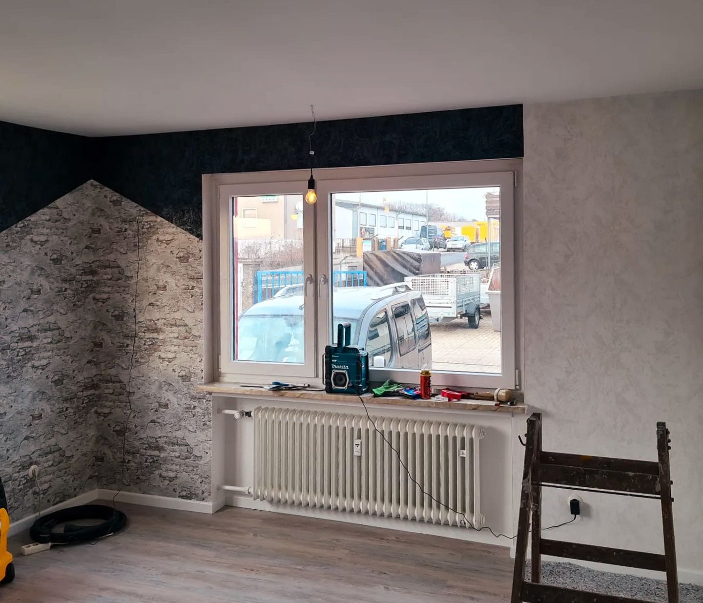 Ein Raum mit großem Fenster und Heizkörper