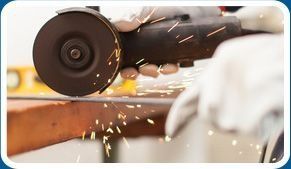 Una persona está cortando un trozo de metal con una amoladora.