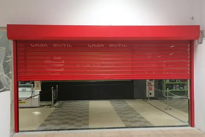 Una persiana roja está abierta en un edificio.