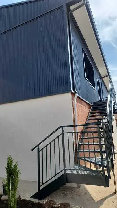 Hay una escalera que conduce al costado de un edificio.