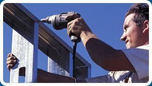 Un hombre está utilizando un taladro en una estructura de metal.