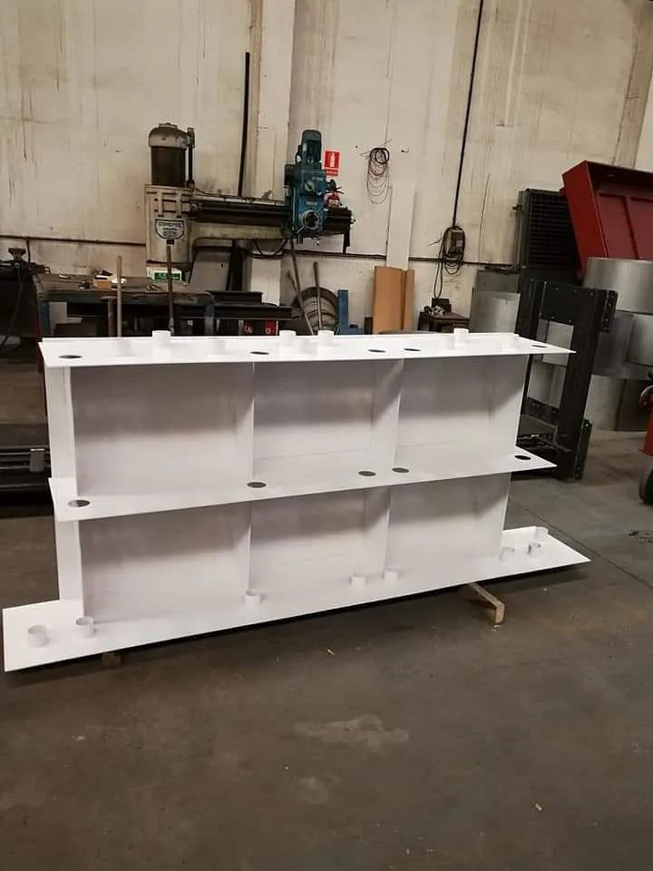 En un almacén hay un estante blanco junto a una máquina.