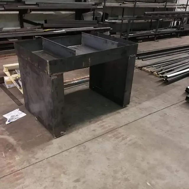Una mesa de metal está colocada sobre un suelo de hormigón en una fábrica.