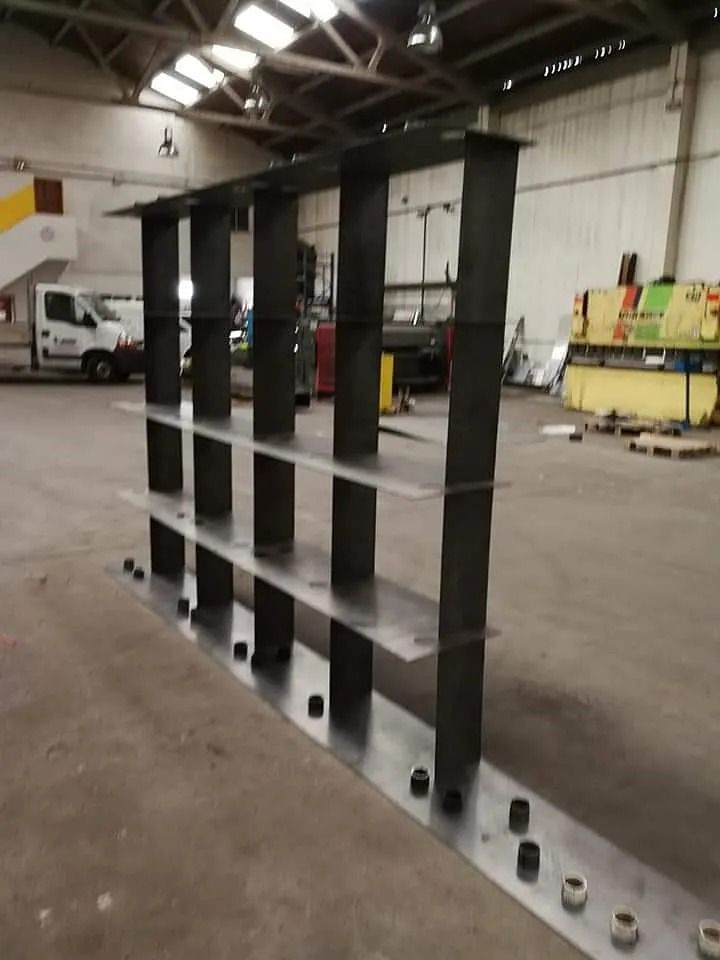 Un estante de metal en un almacén con una furgoneta blanca al fondo.