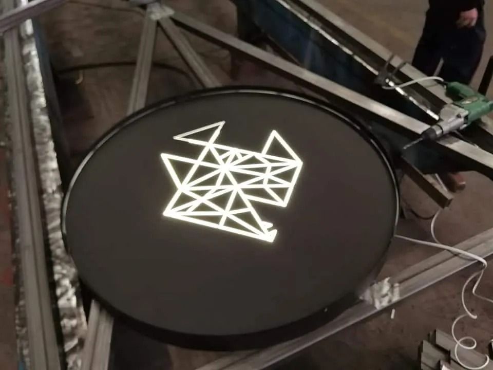 Un círculo negro con un logotipo blanco encima.