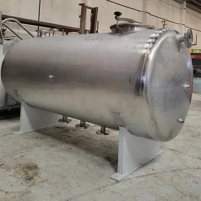 Un gran tanque de acero inoxidable está sentado sobre un soporte blanco.