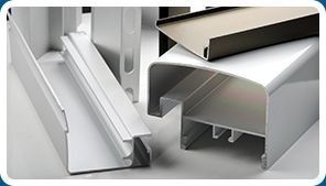 Un grupo de perfiles de aluminio se apilan uno encima del otro sobre una mesa.