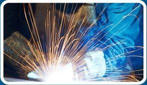 Una persona está soldando un trozo de metal del que salen chispas.