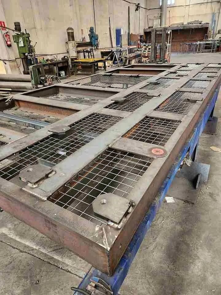 Una gran pieza de metal se encuentra encima de una mesa en una fábrica.