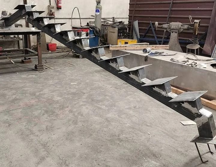 Se está construyendo una escalera de metal en una fábrica.