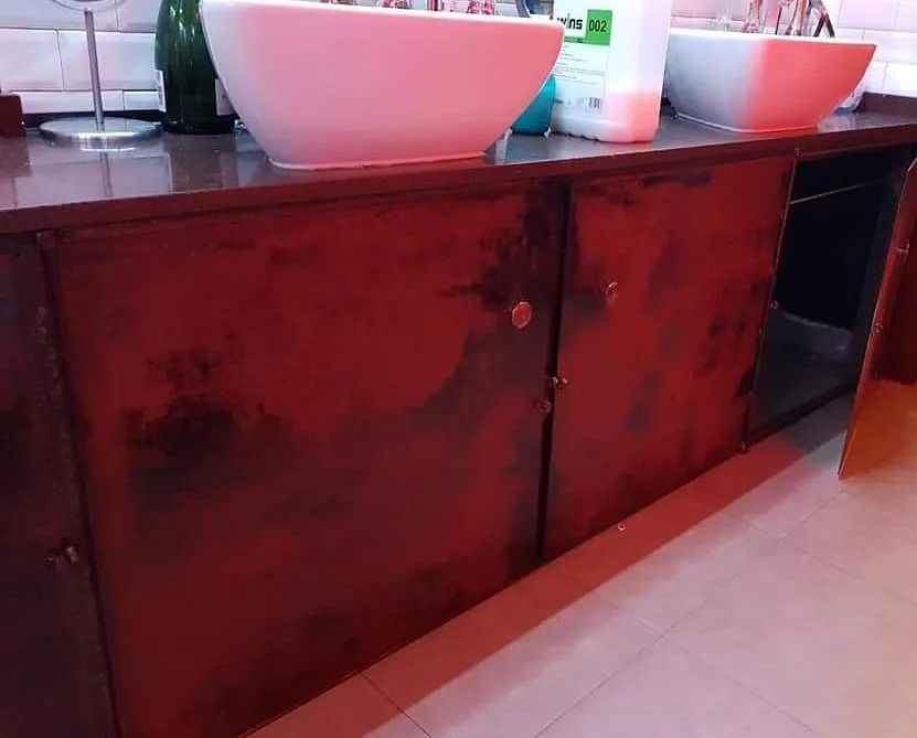 Un baño con dos lavabos y armarios rojos.