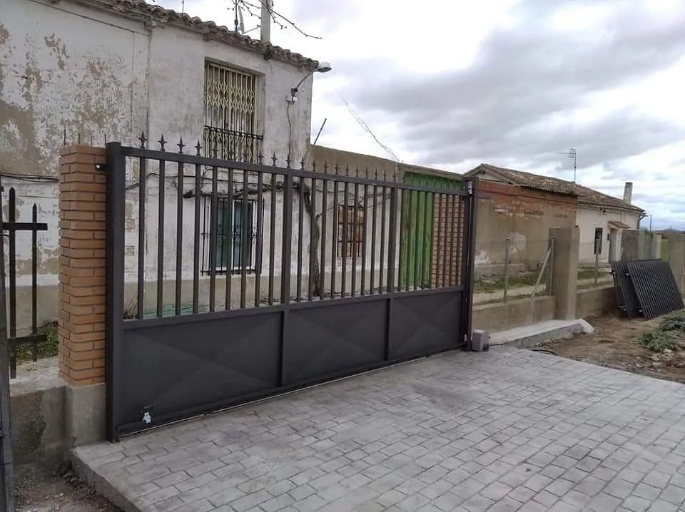 Una puerta negra está frente a un edificio de ladrillos.