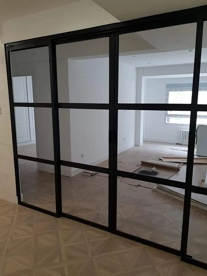Una habitación con muchas ventanas y una puerta corrediza de vidrio.