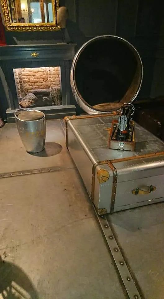 Un baúl está sobre una mesa en una habitación al lado de una chimenea.