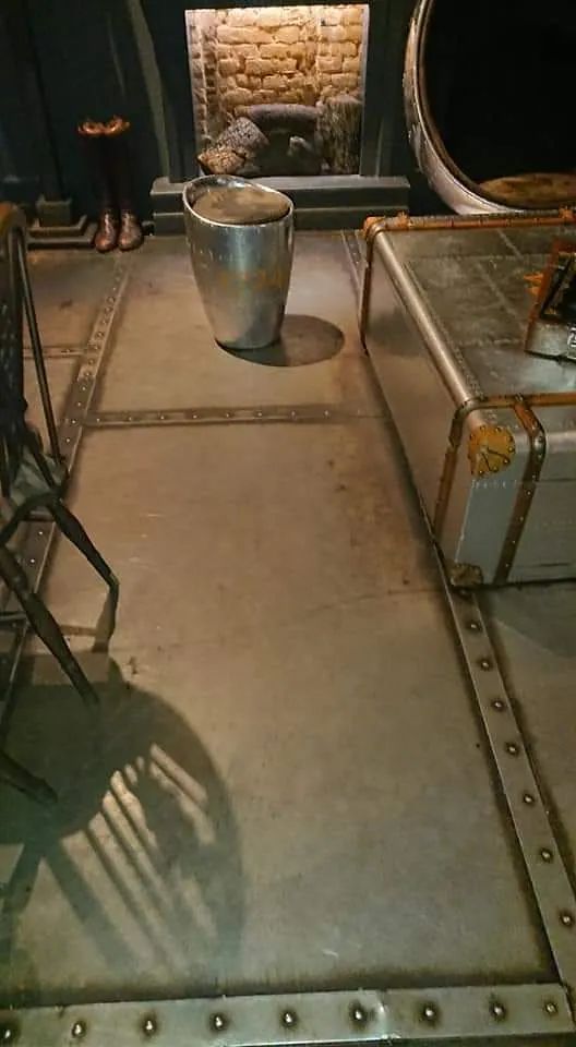 Una sala de estar con chimenea y un baúl en el suelo.