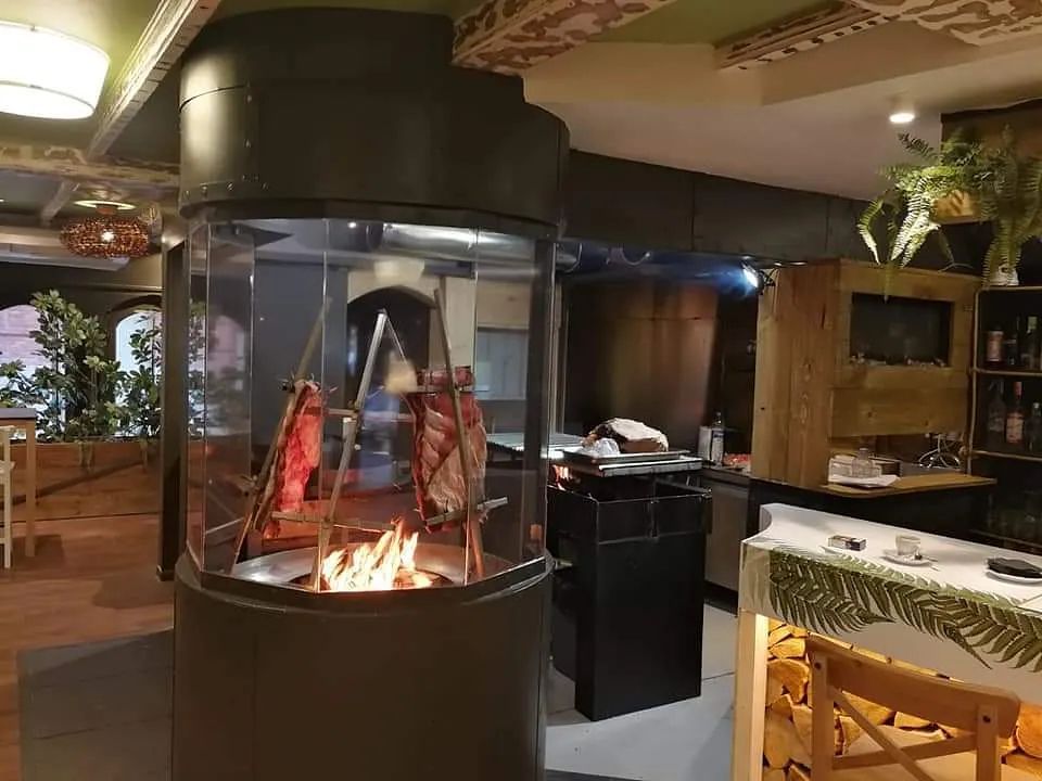 Un restaurante con una chimenea en el centro de la sala.