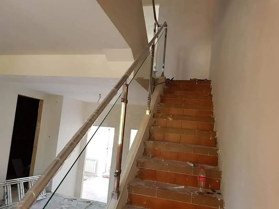 Una escalera con barandilla de cristal en un edificio en construcción.