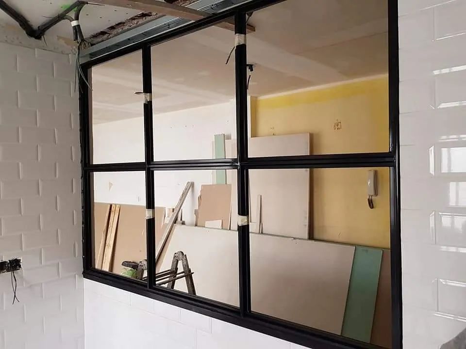 Una gran ventana en una habitación con una escalera al fondo.