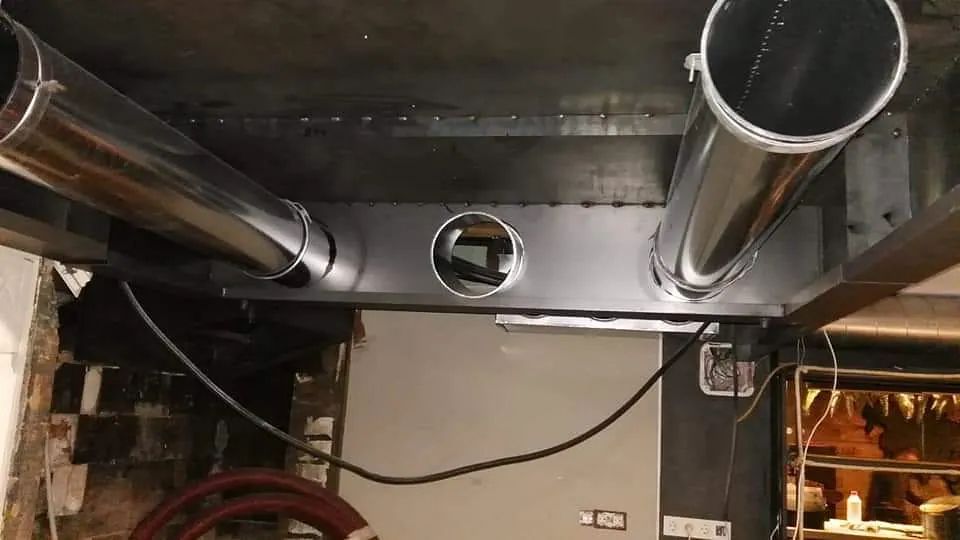 Un montón de tubos de metal cuelgan del techo de un edificio.