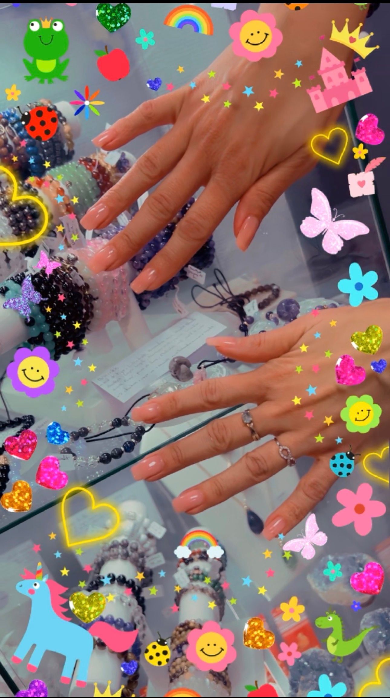Mains aux longs ongles blancs sur une surface colorée ornée d'autocollants en forme de cœur, de fleur et de smiley