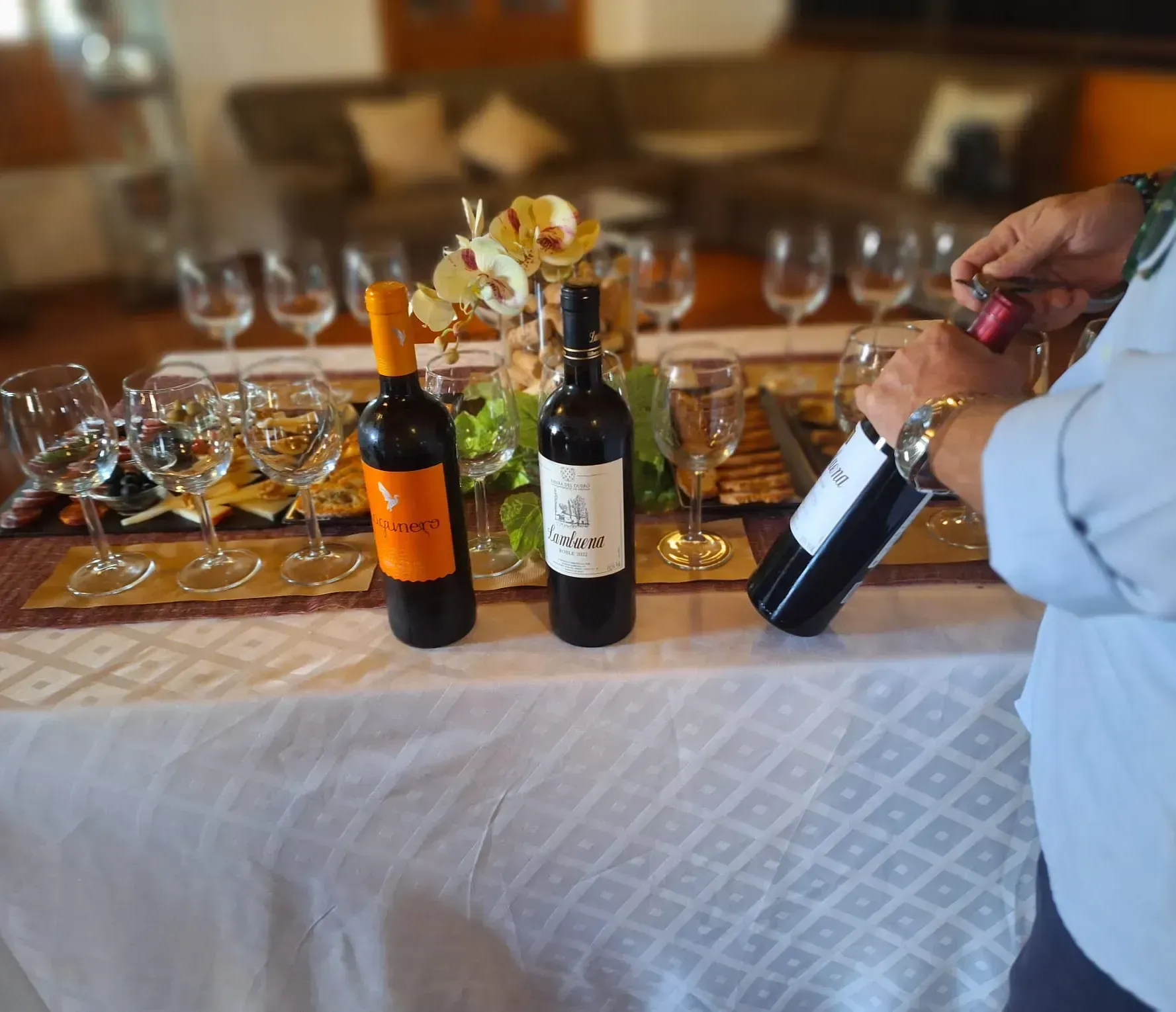 Una persona vertiendo una botella de vino en un vaso