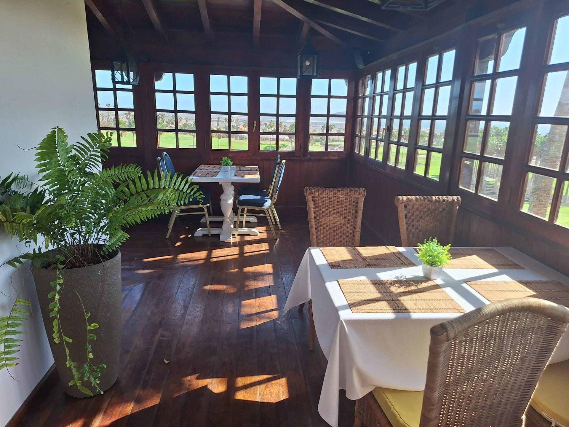 Una mesa y sillas en una habitación con muchas ventanas.