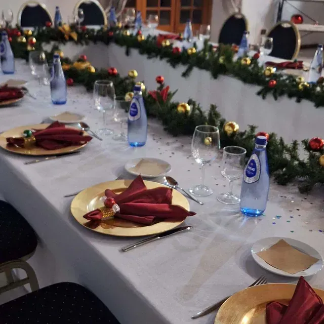 Una mesa larga con platos y botellas de agua aquafina.