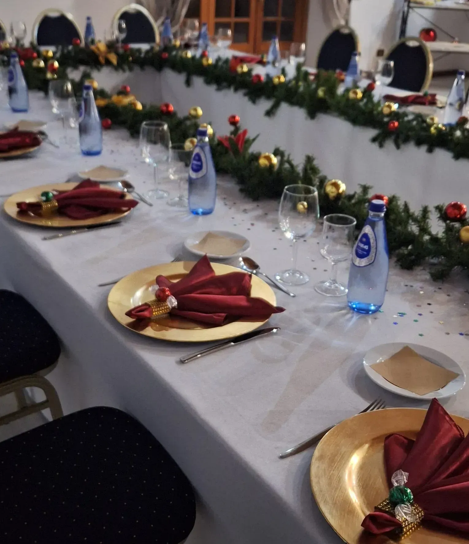 Una botella de agua Aquafina reposa sobre una mesa larga.