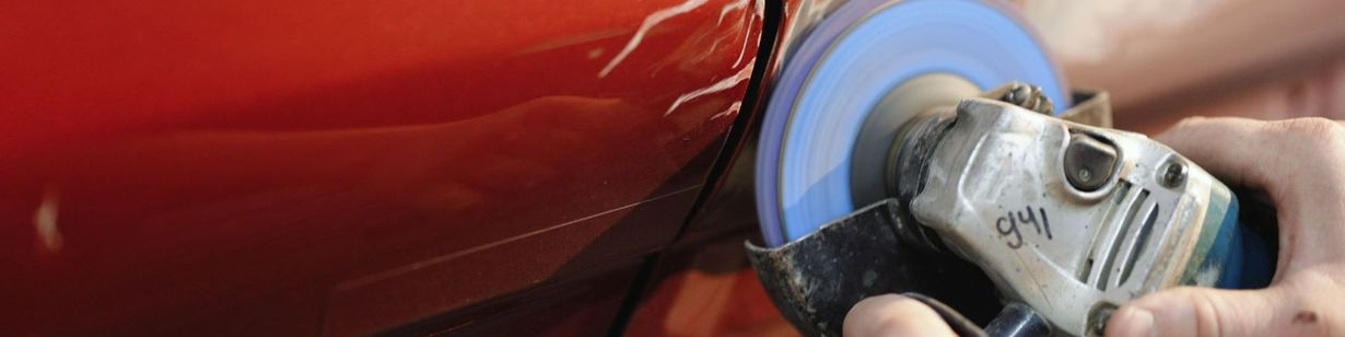 Un mécanicien en train de réparer la carrosserie d'une voiture.