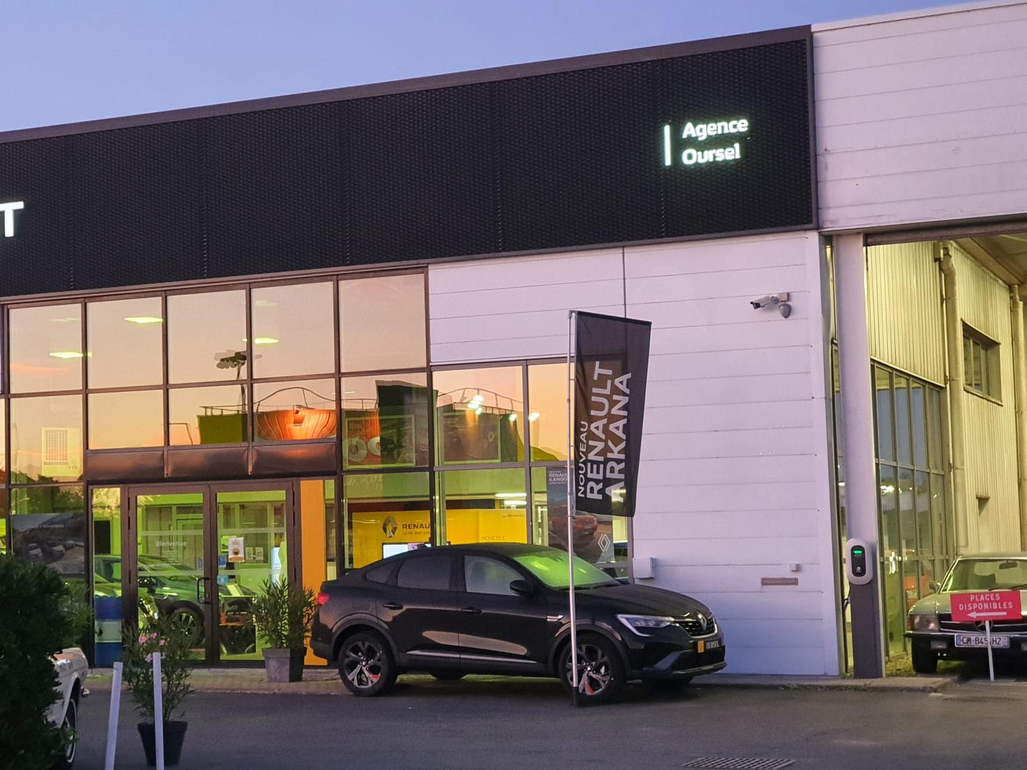 Devanture du garage avec une Renault Arkana devant.