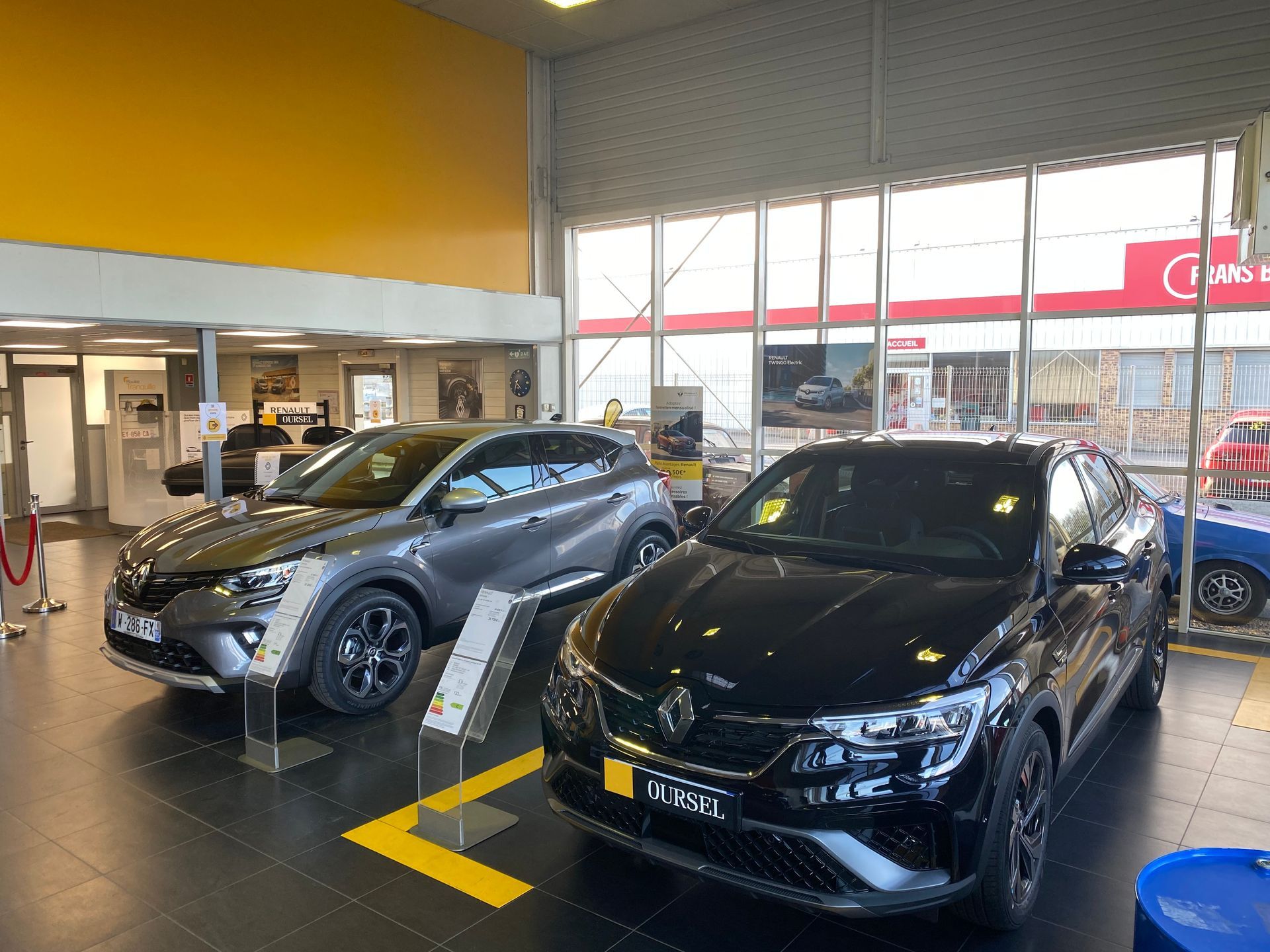 Deux voitures Renault en exposition dans un garage automobile. 