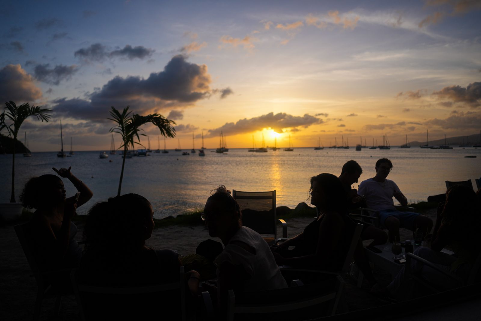 Deux femmes assises devant la plage trinquent