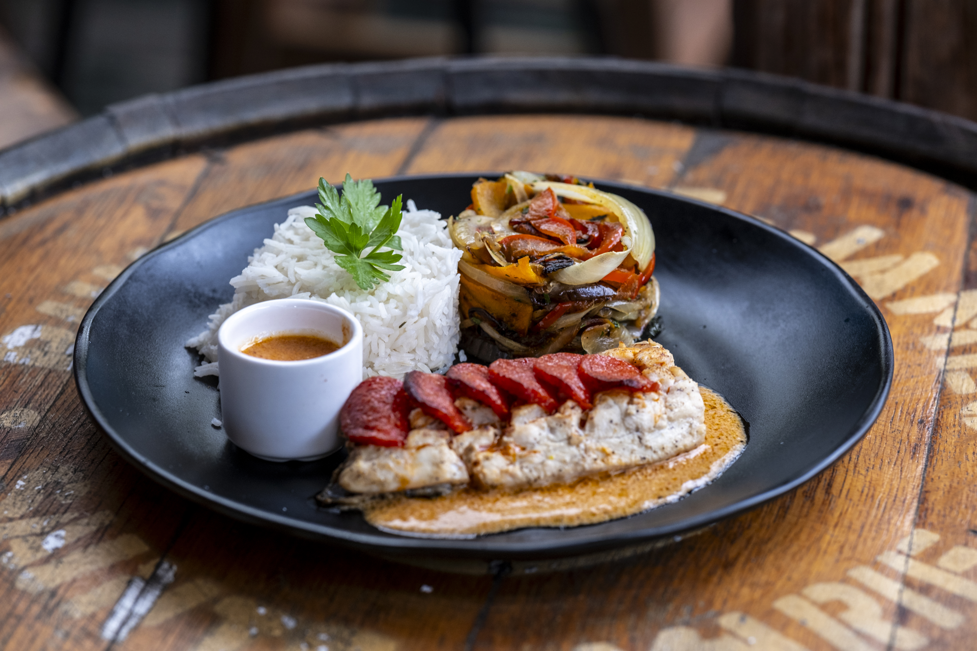 Une assiette noire avec du riz et du poisson