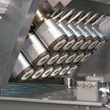 Pièces métalliques industrielles disposées en rangées sur une machine de fabrication d'acier inoxydable
