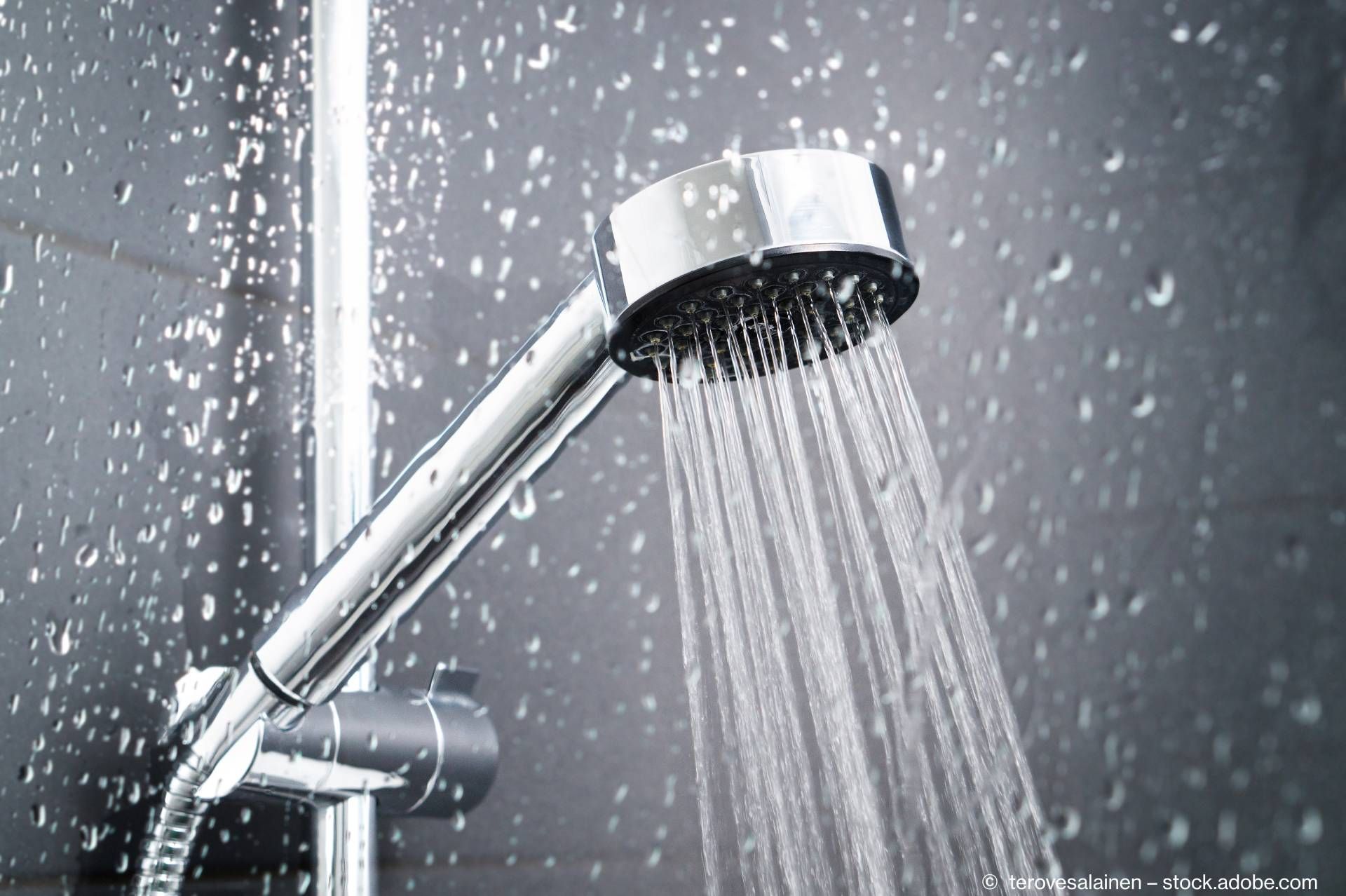 Wasser läuft aus Duschkopf und Wasserhahn im modernen Badezimmer.