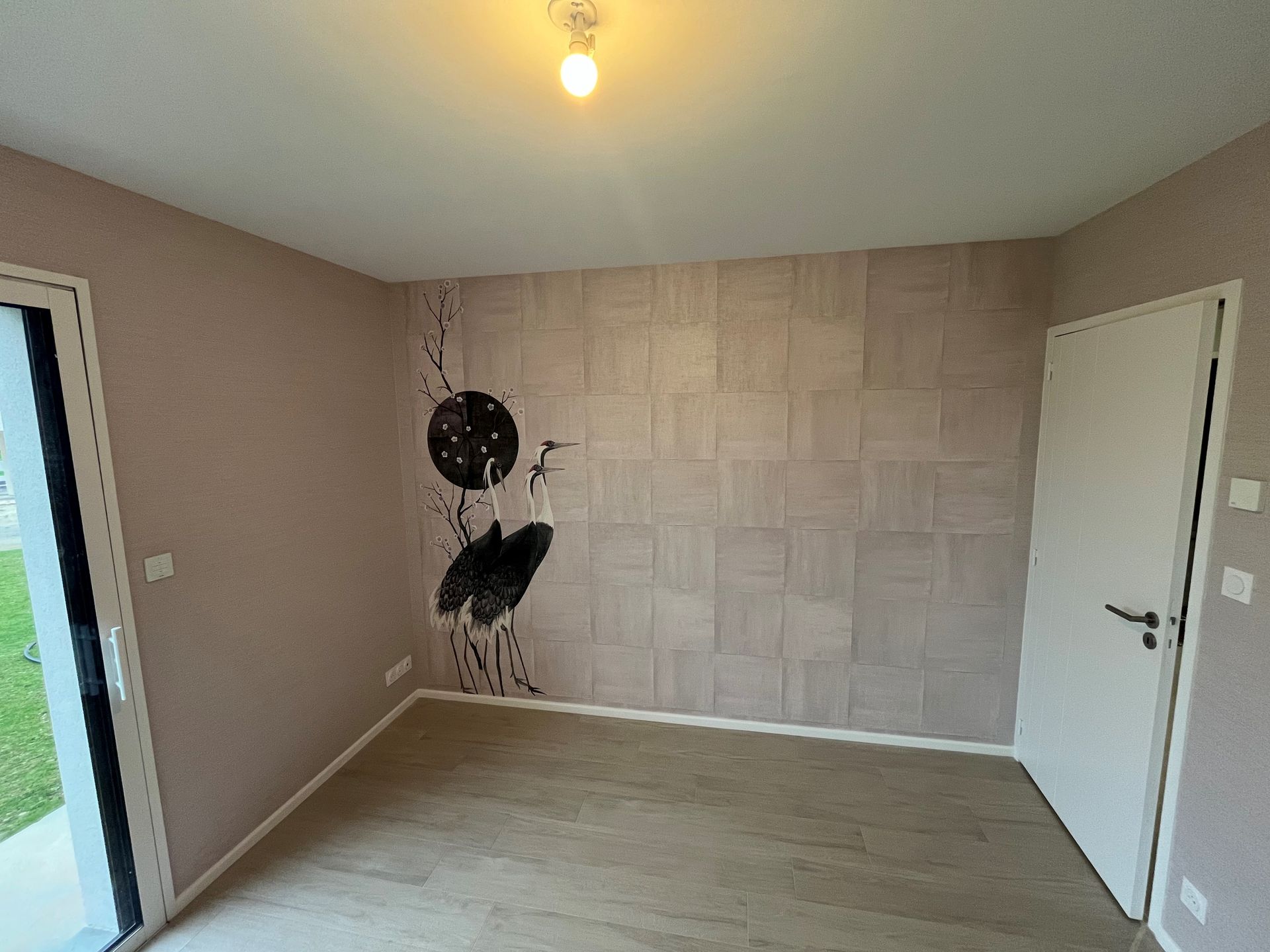 Pièce beige vide avec un mur avec décoration panoramique, une horloge et des portes sur deux côtés.