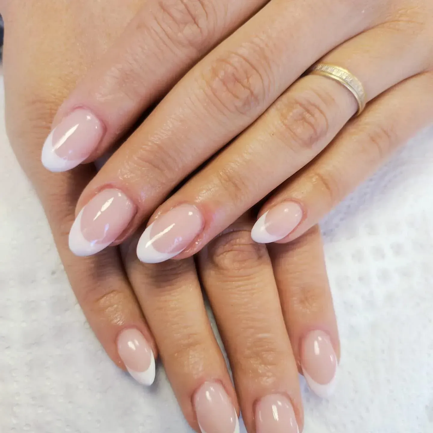 Un primer plano de las uñas de una mujer con un anillo en el dedo.