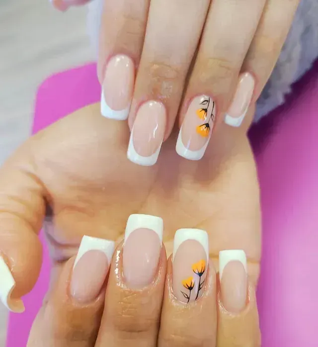 Un primer plano de las uñas de una persona con un diseño floral en ellas.