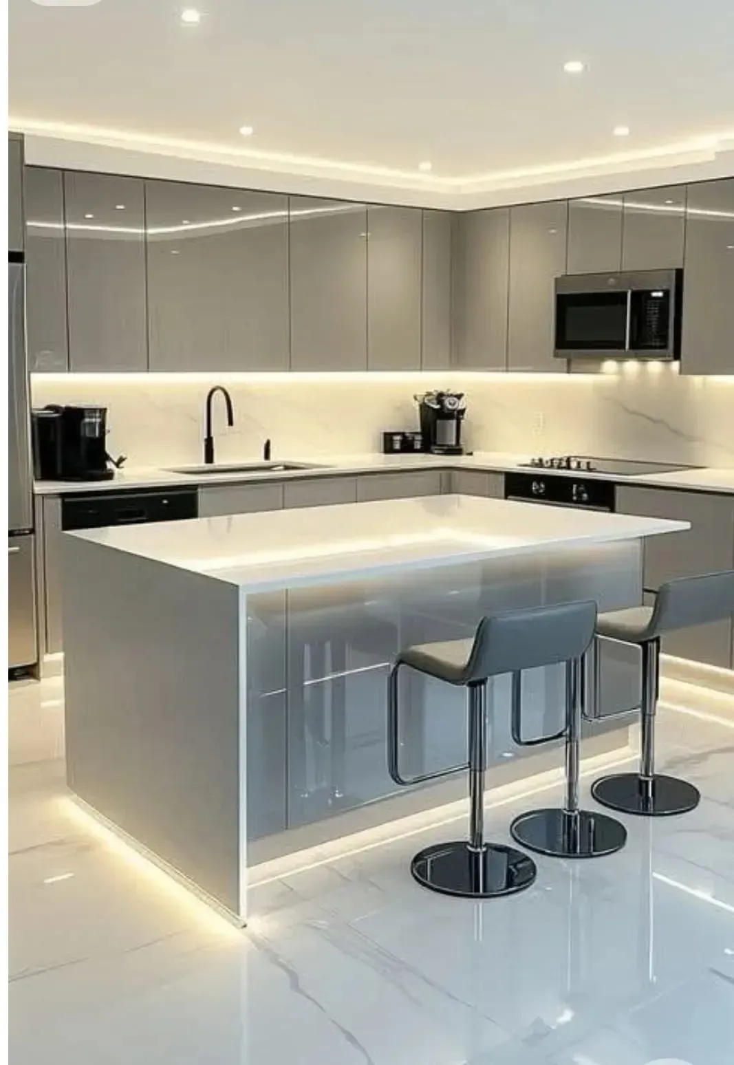 Una cocina moderna y elegante de color gris con una isla blanca con efecto cascada, taburetes de bar,.