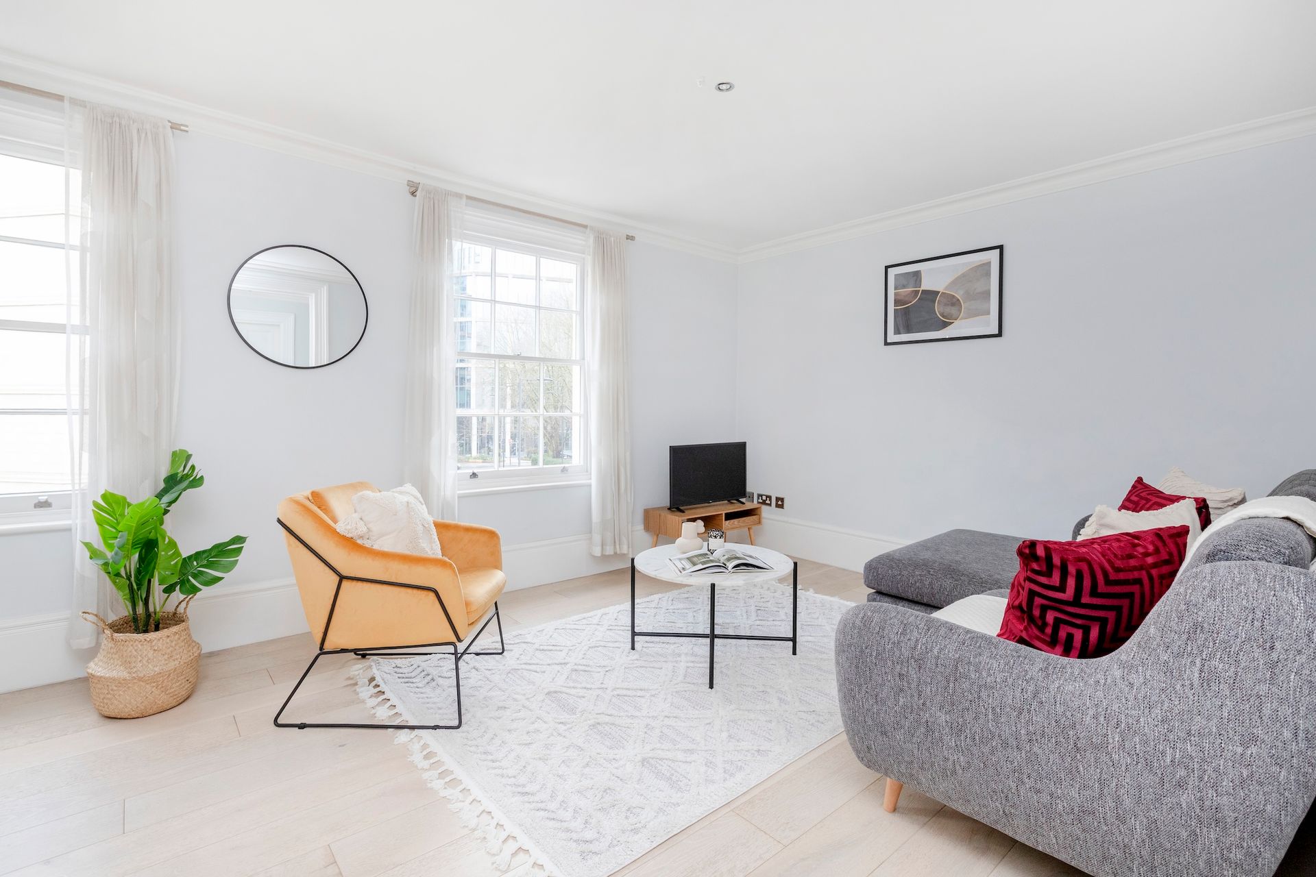 A living room with a couch , chair , coffee table and television.