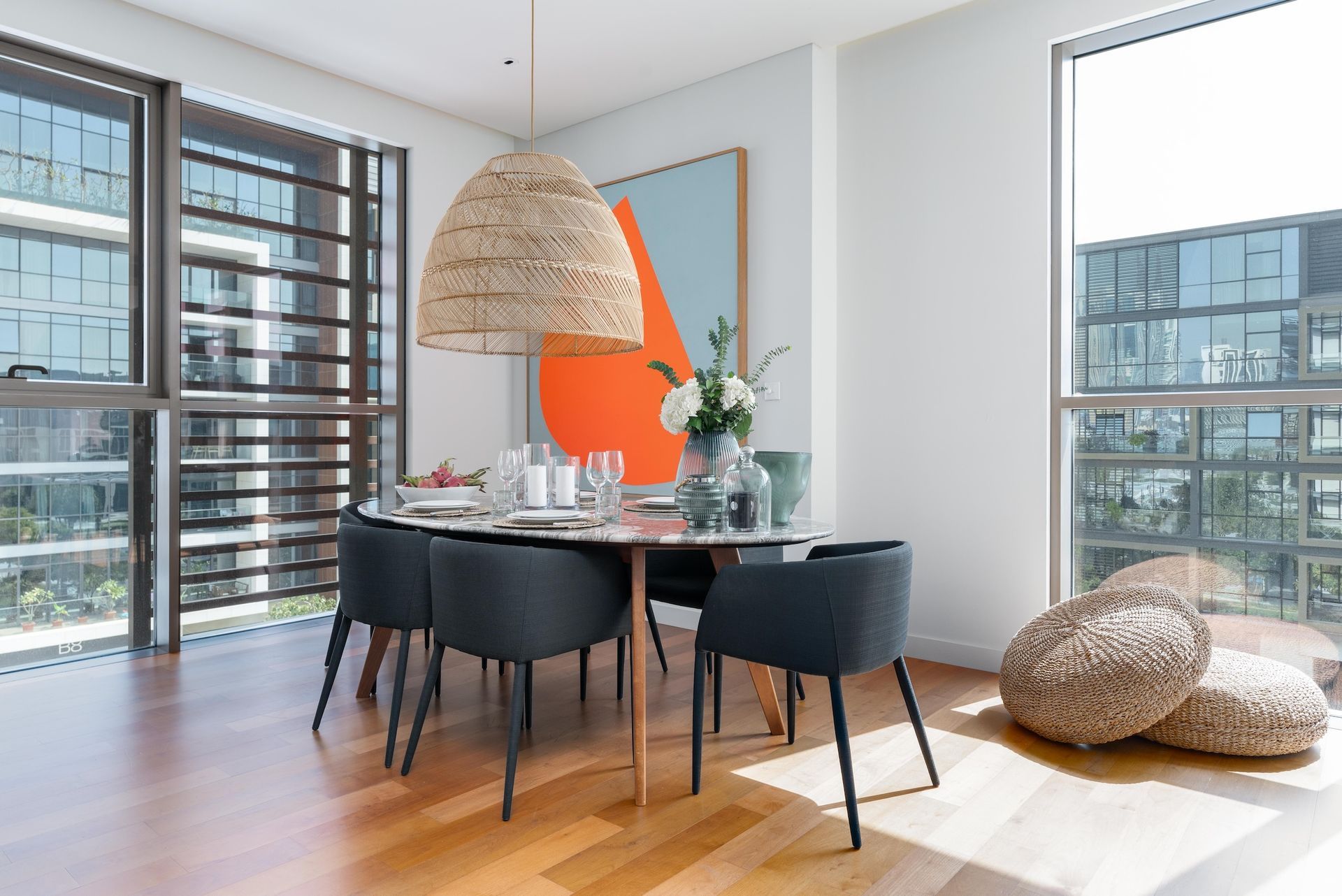 A dining room with a table and chairs and a large window
